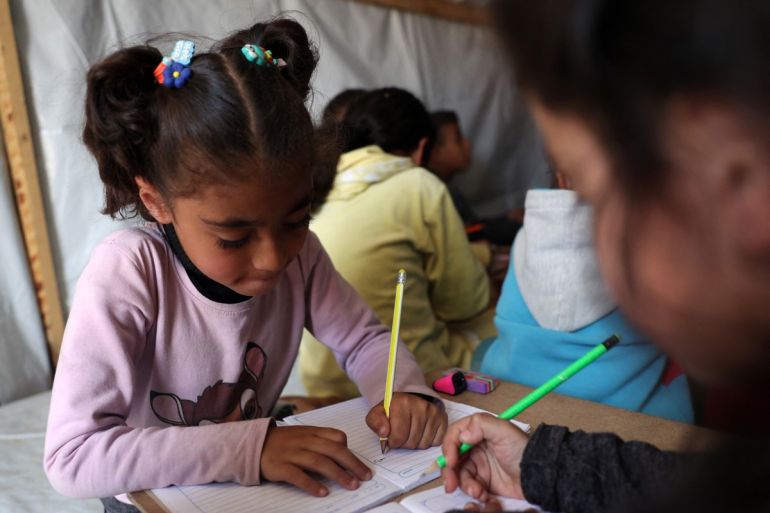 Children attend class at a makeshift classroom in a camp for displaced Palestinians in Rafah