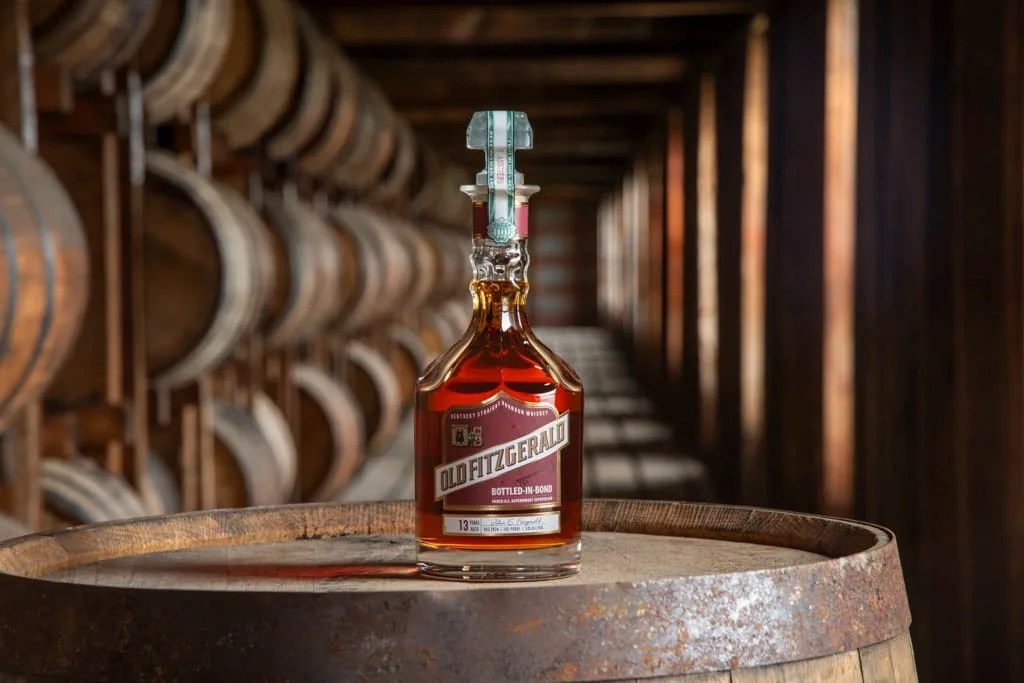 2024 Bottle of Old Fitzgerald Bottled-in-Bond VVS bourbon sitting on bourbon barrel in a bourbon wearehouse.