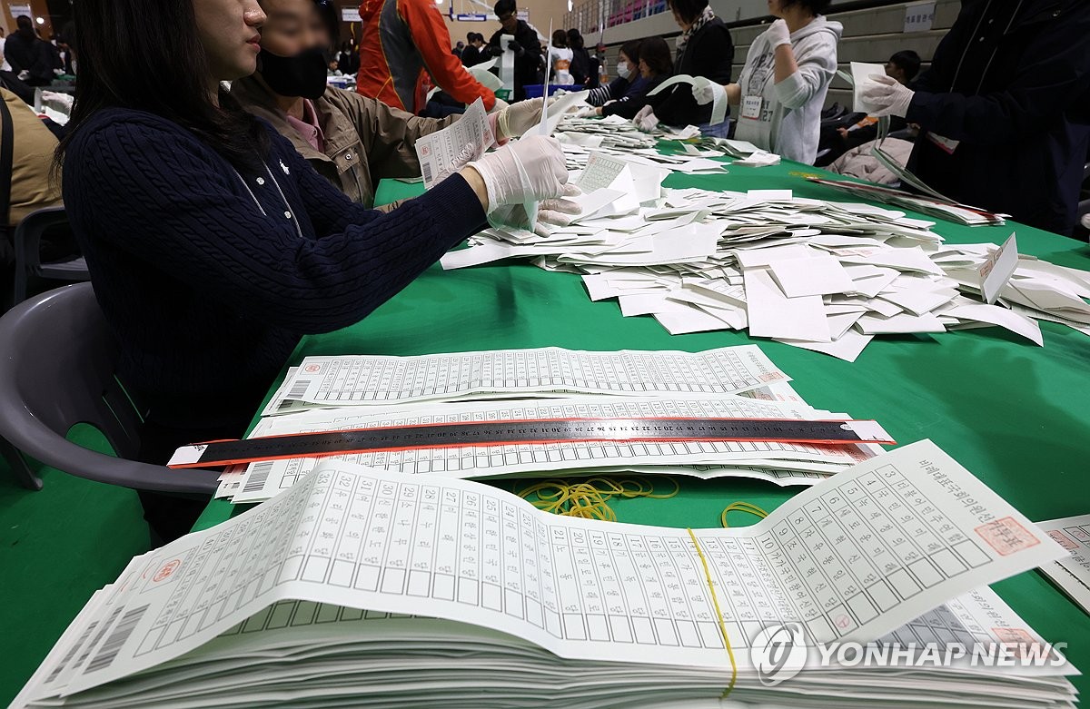 Proportional representative ballots are piled up next to election officials counting ballots for the 22nd general elections in the city of Chuncheon, 76 kilometers northeast of Seoul, on April 10, 2024. (Yonhap)