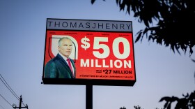 A sign showing Thomas J. Henry, advertising a $50 million judgement for a client