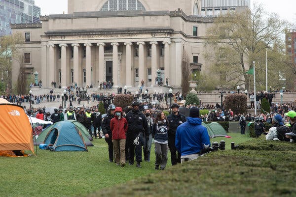 The Columbia lawn, with police leading students away.