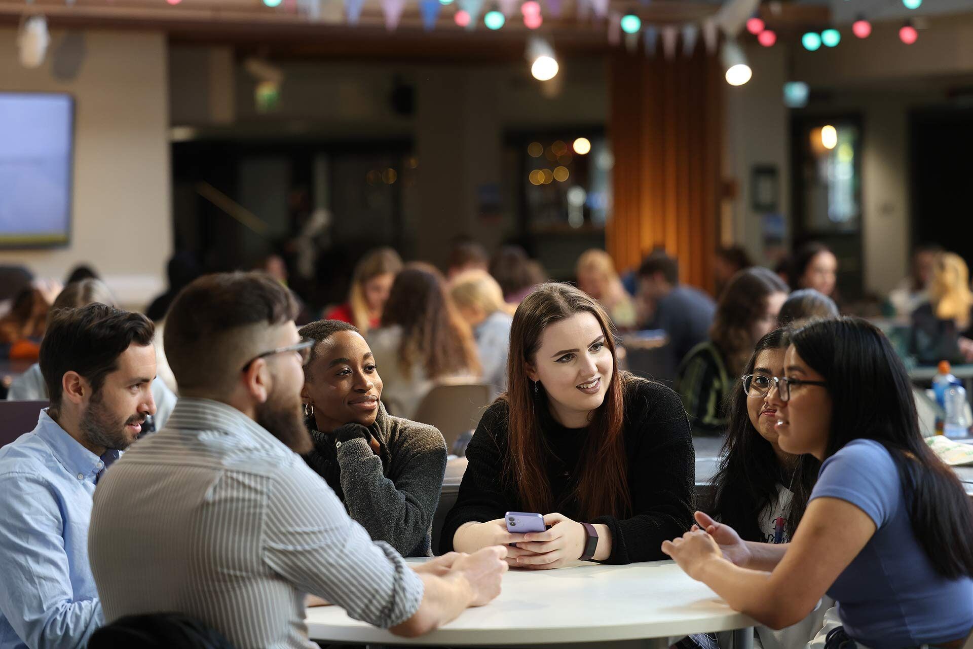 Postgraduate students hold a discussion while sat round a table in in the Liverpool Guild of Students.