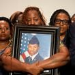 Mika Fortson, mother of Roger Fortson, a U.S. Navy airman, holds a photo of her son during a news conference with Attorney Ben Crump, Thursday, May 9, 2024, in Ft. Walton Beach, Fla. Fortson was shot and killed by police in his apartment on May 3, 2024. (AP Photo/Gerald Herbert)