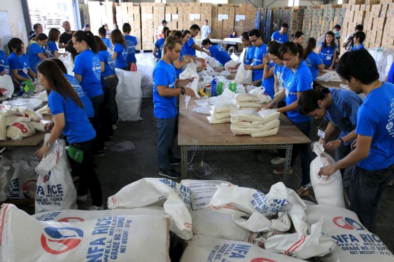 Volunteers repack food rations for victims of Typhoon Noul at the Department of Social Welfare Development headquarters in Pasay city