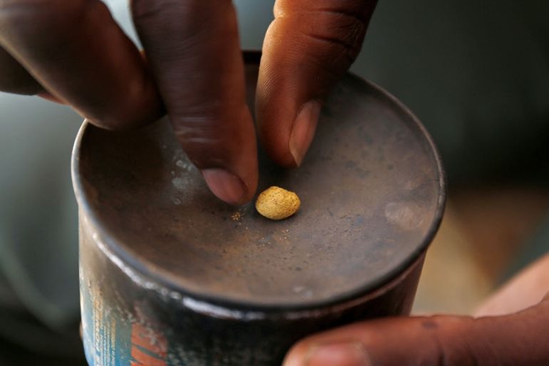 An artisanal gold miner picks up a gold nugget at an unlicensed mine in Gaoua, Burkina Faso