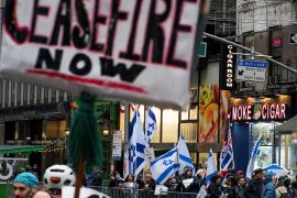 People hold Israeli flags as protesters hold a rally in front of the AIPAC offices demanding a ceasefire and the end of Israel&#039;s attacks on Gaza, in New York City, US [File: Eduardo Munoz/Reuters]