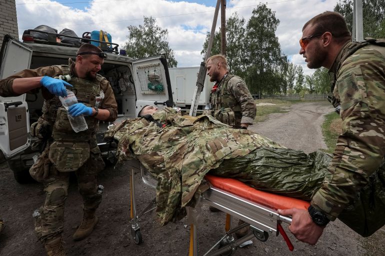 Military paramedics treat a wounded Ukrainian service member, amid Russia's attack on Ukraine, near the town of Vovchansk in Kharkiv region, Ukraine May 12, 2024. REUTERS/Vyacheslav Madiyevskyy