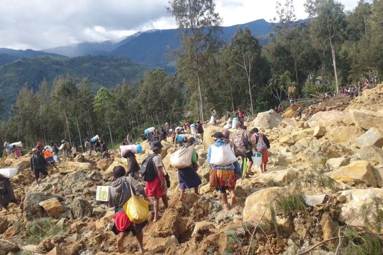 Residents carry their bags in the aftermath of a deadly landslide in Enga province of Papua New Guinea