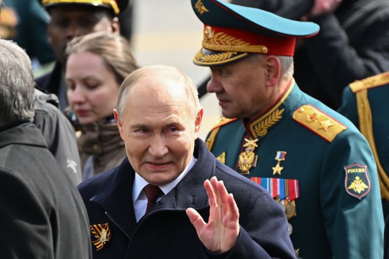 Russia's President Vladimir Putin (L) and Russia's Defence Minister Sergei Shoigu (R) leave Red Square