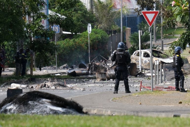 A French gendarme on the street in Noumea. There is debris around him.