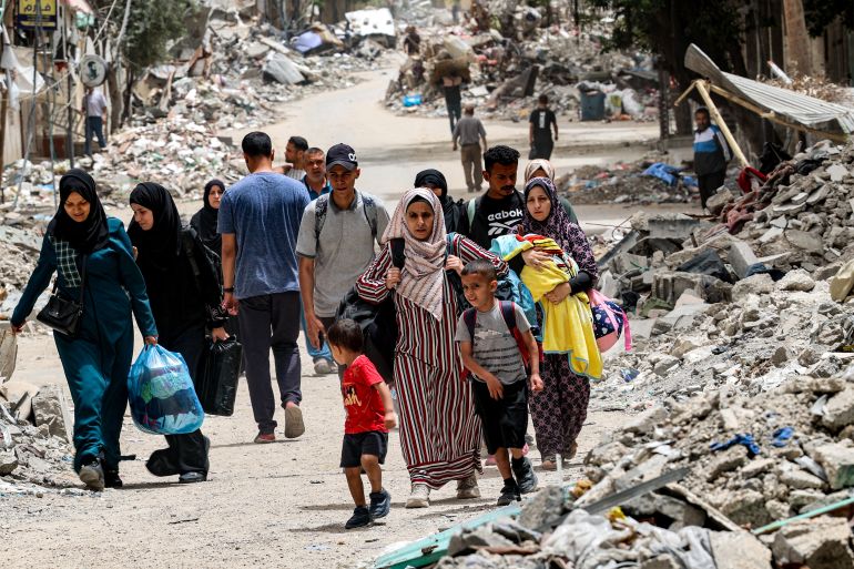 Displaced Palestinians evacuate from the Tal al-Zaatar camp for Palestinian refugees in the northern Gaza Strip on May 11