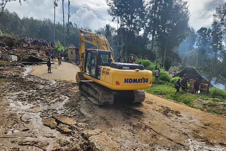 This handout photo taken and received on May 26, 2024 from the International Organization for Migration shows an excavator driving towards the site of a landslide at Yambali Village in the region of Maip Mulitaka, in Papua New Guinea's Enga Province. More than 670 people are believed dead after a massive landslide in Papua New Guinea, a UN official told AFP on May 26 as aid workers and villagers braved perilous conditions in their desperate search for survivors. (Photo by Mohamud Omer / International Organization for Migration / AFP) / NO USE AFTER JUNE 5, 2024 10:36:26 GMT - RESTRICTED TO EDITORIAL USE - MANDATORY CREDIT "AFP PHOTO / INTERNATIONAL ORGANIZATION FOR MIGRATION / MOHAMUD OMER - NO MARKETING NO ADVERTISING CAMPAIGNS - DISTRIBUTED AS A SERVICE TO CLIENTS - NO ARCHIVE