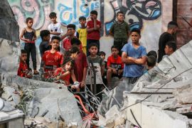 Palestinian children stand next to the rubble of the Zaqout family&#039;s house hit during overnight Israeli bombardment in Nuseirat [Bashar Taleb/AFP]