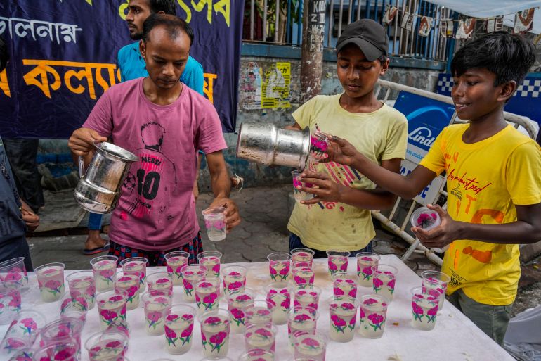 Volunteers of a local charitable trust distribute drinking water to people on a street as heat wave continues in Kolkata, India, Thursday, May 9, 2024. (AP Photo/Bikas Das)