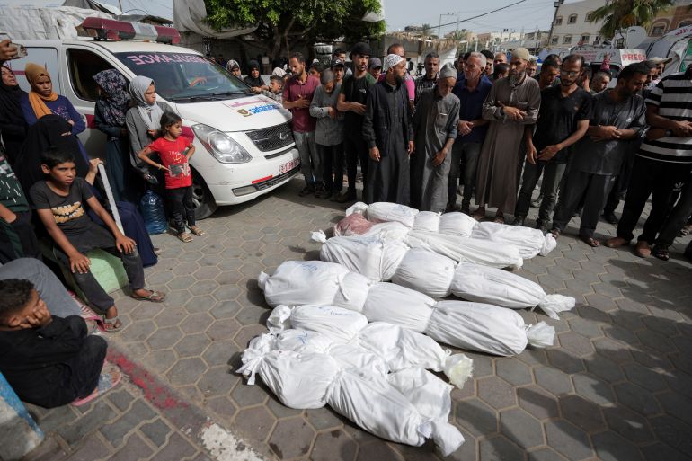 Palestinians pray next to the bodies of their relatives killed in an Israeli bombardment