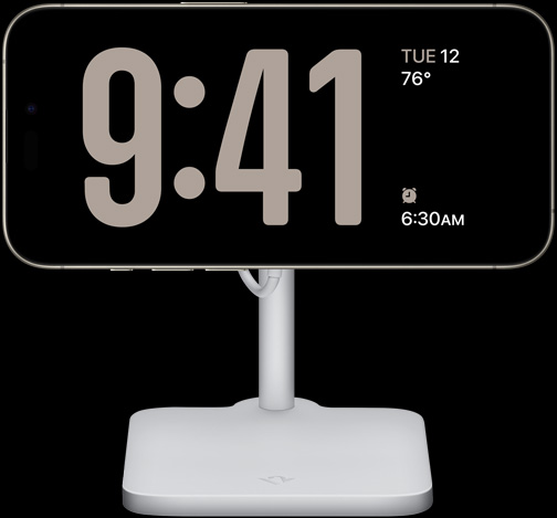 iPhone 15 Pro no modo Em espera a mostrar um relógio em ecrã completo juntamente com a data, a temperatura e o próximo alarme