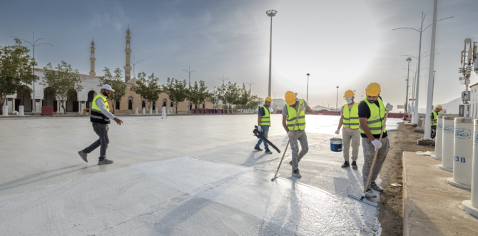 Workers apply the “cool pavements” material to the area around the Namirah Mosque in Arafat. (@RGAsaudi)