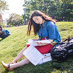 Woman completing course work on the lawn