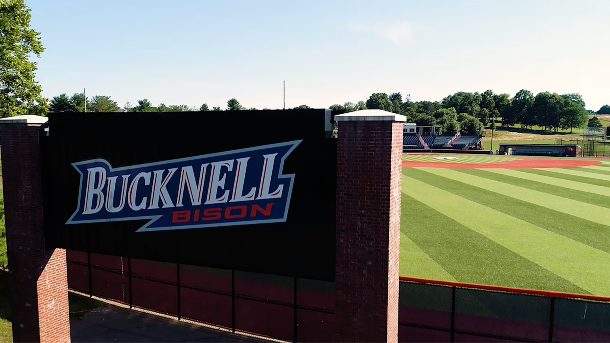 Bucknell logo on wall behind baseball field.