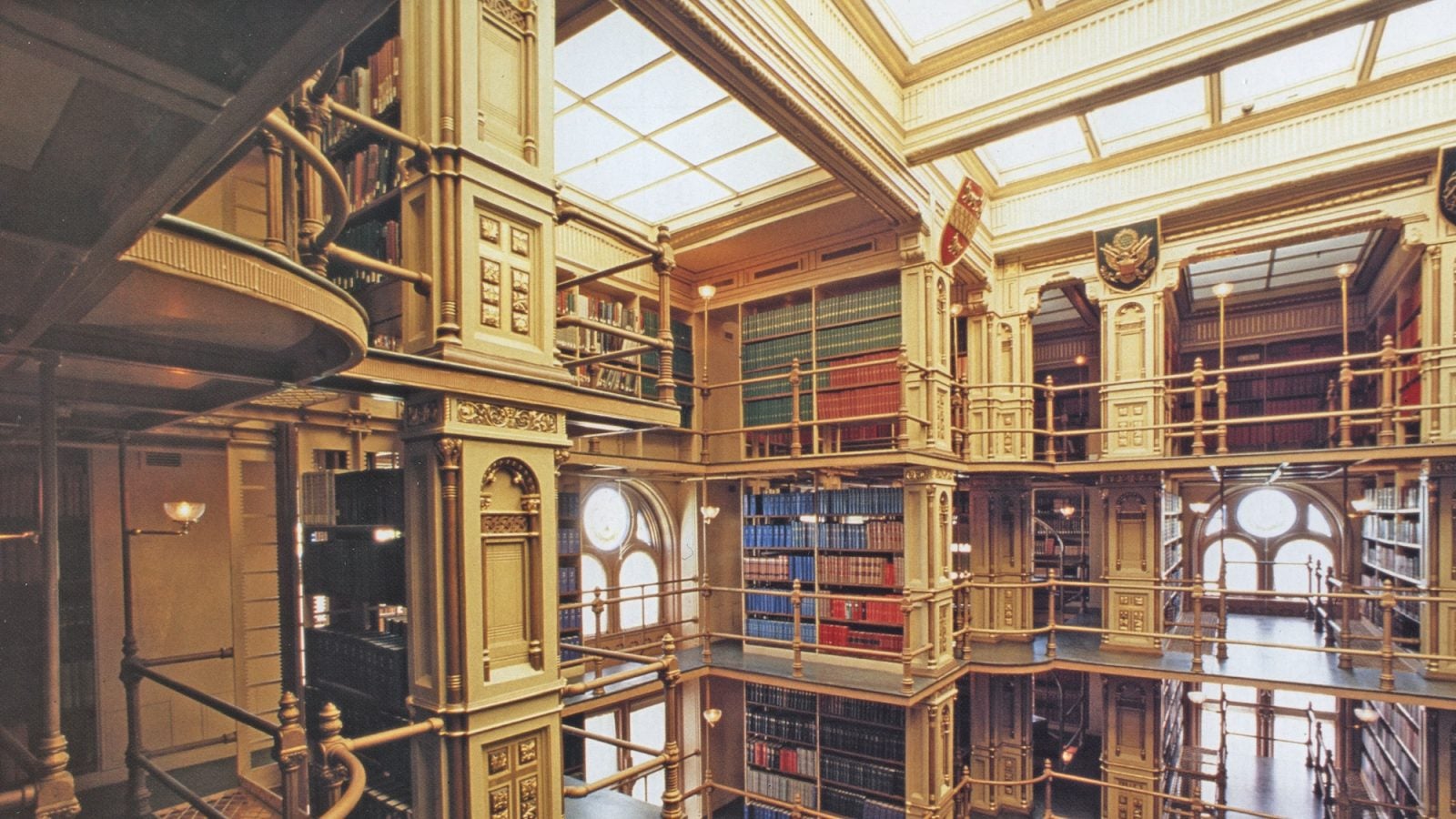 Victorian cast iron library with sky lights, bookshelves, and walkways.