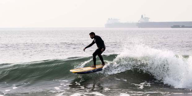 A surfer rides a wave at Belmont Shore in Long Beach, CA on Friday, Dec. 29, 2023. Waves are rare along this stretch of coast, but sometimes swell is able to sneak past the breakwater. (Photo by Paul Bersebach, Orange County Register/SCNG)