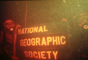 divers holding a National Geographic Society banner underwater