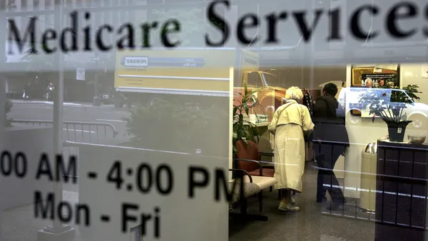 Two people are seen inside a Medicare Services office.
