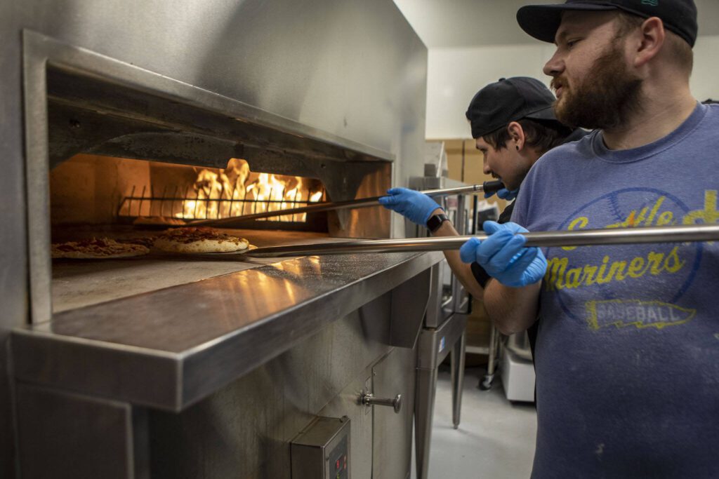 Line cook Kip Dahl, 29, prepares a pizza at the new Sound2Summit taproom in Everett, Washington, on Friday, June 9, 2023. (Annie Barker / The Herald)
