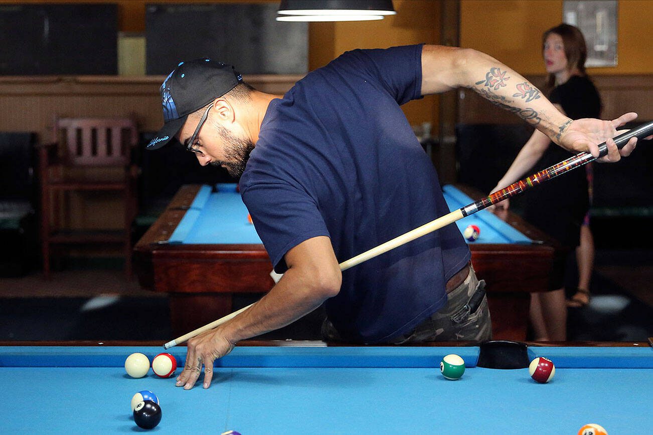 Wilker Leite lines up a shot Wednesday afternoon at the Golden Fleece pool hall in Everett on July 31, 2019. (Kevin Clark / The Herald)