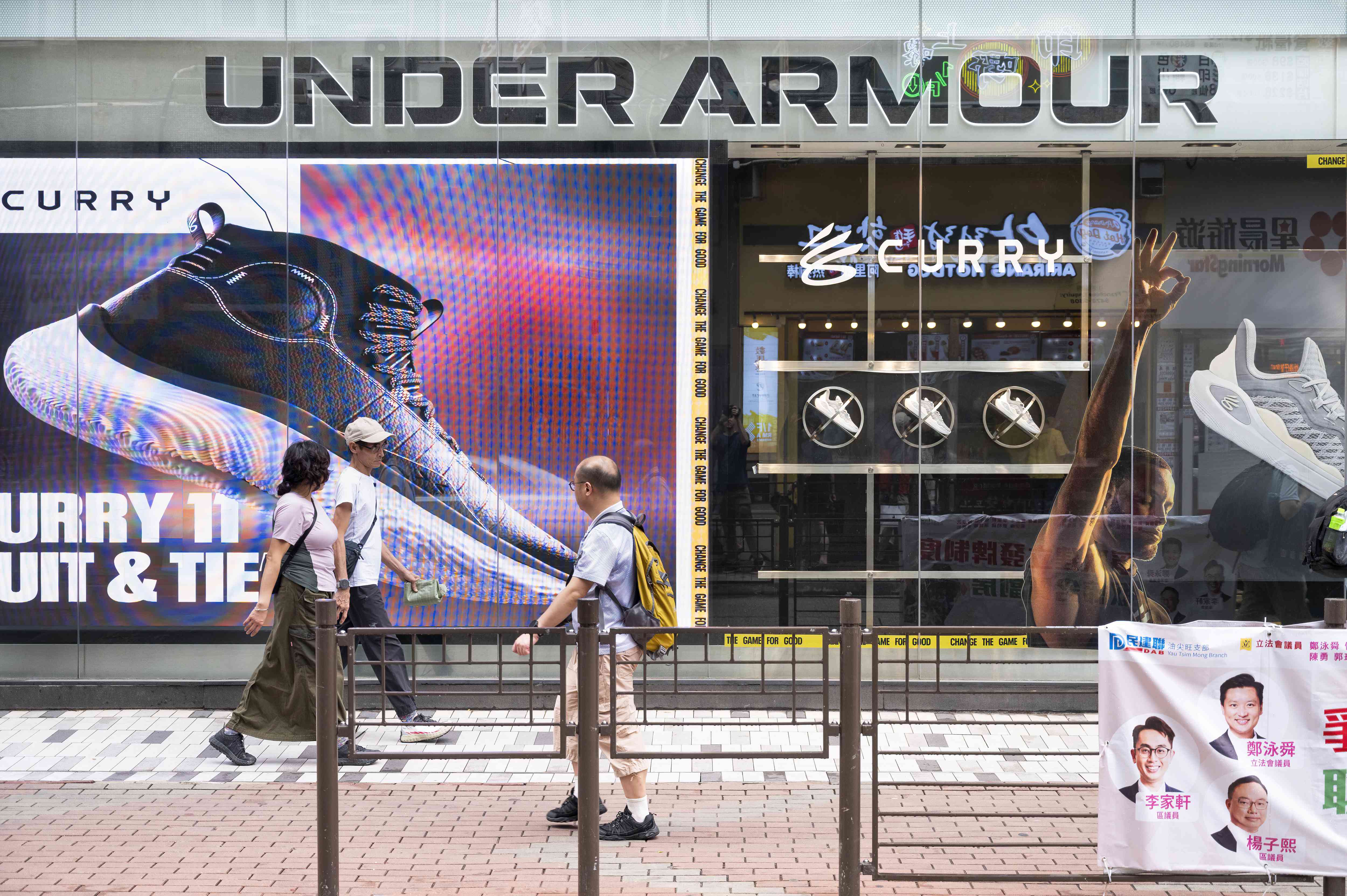 Pedestrians walk past the American multinational clothing brand Under Armour store in Hong Kong