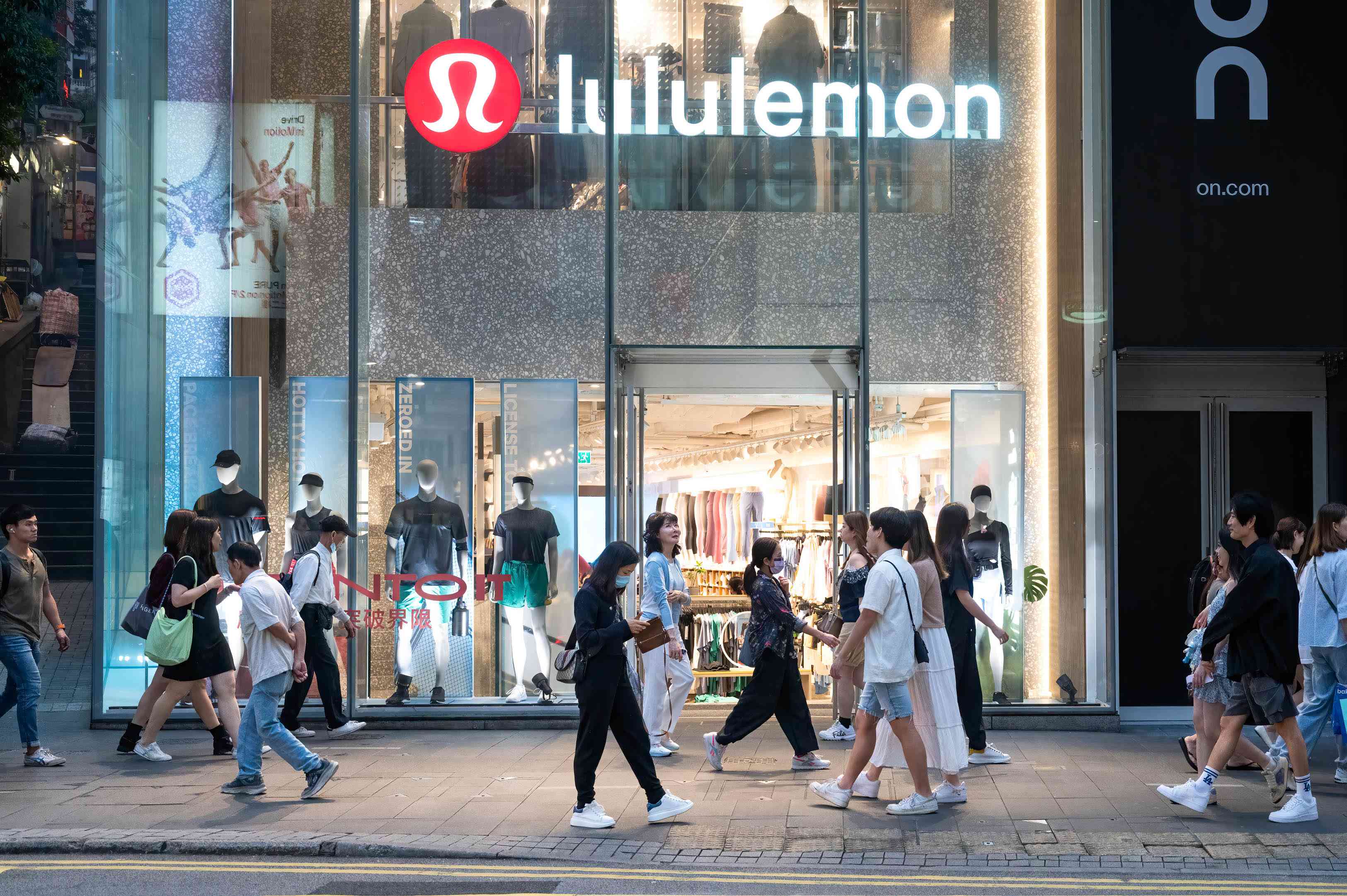 Pedestrians walk past a Lululemon store in Hong Kong