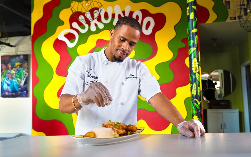 Chef mettant la touche finale à un plat au Dukunoo Jamaican Kitchen