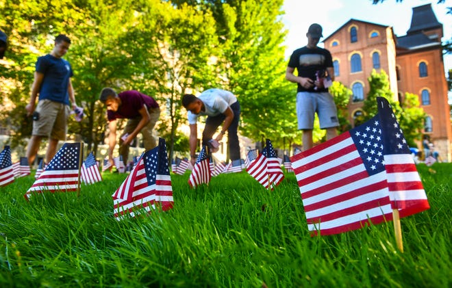 Students place more than 2,700 flags in memorial of victims of the Sept. 11 attacks near the quad at St. John's University Tuesday, Sept. 10. The event was organized by the CSB/SJU College Republicans. Students with the St. John's fire department also planned to climb 104 floors of stairs in commemoration of the event on Wednesday.