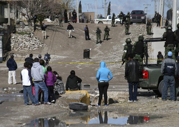 4 February: People look at a rubbish bin containing a dead body in Ciudad Juarez