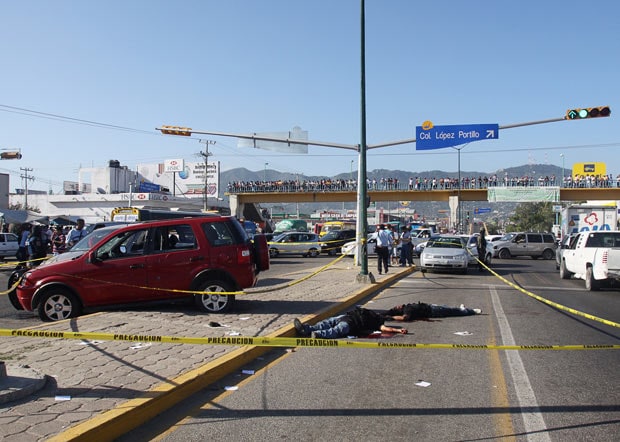 14 March: Police cordon off an area where the bodies of two men were found lying dead on a road in Acapulco