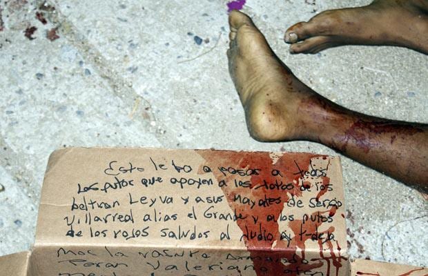 22 March: A message written on a cardboard box with warnings to other rival gangs lies on the floor next to sawn-off legs that were found in the early hours in the resort city of Acapulco