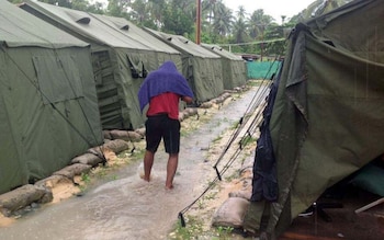a man walking between tents at Australia's regional processing centre on Manus Island in Papua New Guinea