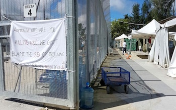 A sign adorns the security fence near shelters inside the Manus Island detention centre in Papua New Guinea, February 11, 2017