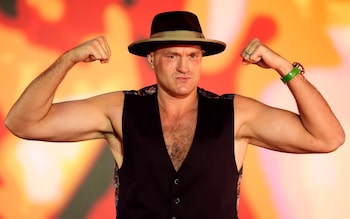 Tyson Fury wearing a hat and flexing his muscles
