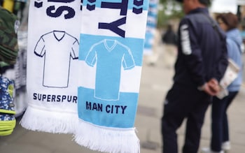 Matchday scarves are sold ahead of the English Premier League soccer match between Tottenham Hotspur and Manchester City, in London