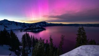 The aurora borealis appears over Crater Lake in Oregon during the solar storm last weekend