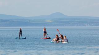 Paddlers at Portobello Beach on the Firth of Forth could enjoy the warm weather typically brought to Scotland in May by changes in the prevailing winds