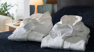 Folded bathrobes on a hotel bed