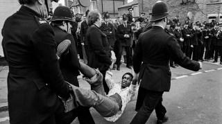 Police detain a man during clashes between the National Front and antiracist demonstrators in Lewisham, southeast London, 1977