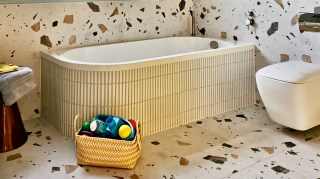 Terrazzo tiling and a rounded bath, in a bathroom designed by Karen Knox, make for a considered space for two young boys