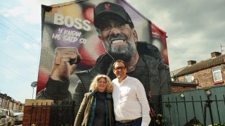 Alyson Rudd and Tony Cascarino in front of a mural of Jürgen Klopp near Anfield