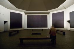 Man sitting in chapel designed by painter Mark Rothko