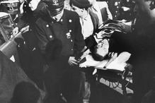 Malcolm X's body being carried on a stretcher after his assassination.