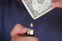 Person burning dollar note