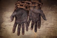 black hands bound in heavy, rusty chains